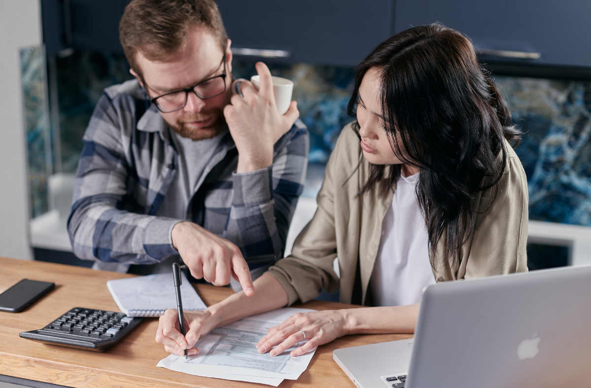 Two people calculating prices on paper.