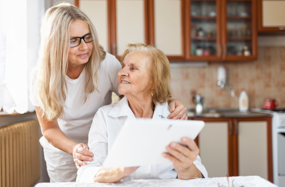 An older person being supported in her dining room.